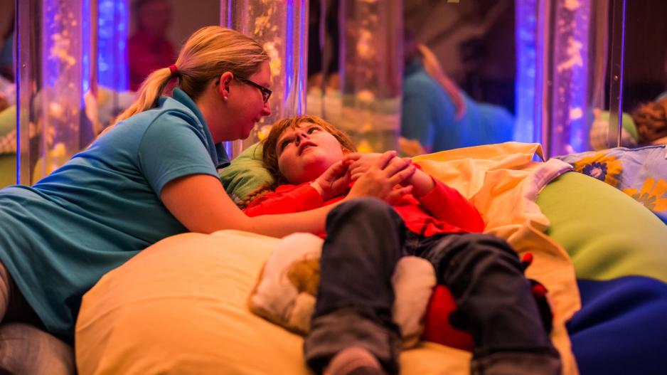 Kinderhospiz Regenbogenland Foto Kinderhospiz Regenbogenland. Ein Kind wird im Entspannungsraum liebevoll begleitet.