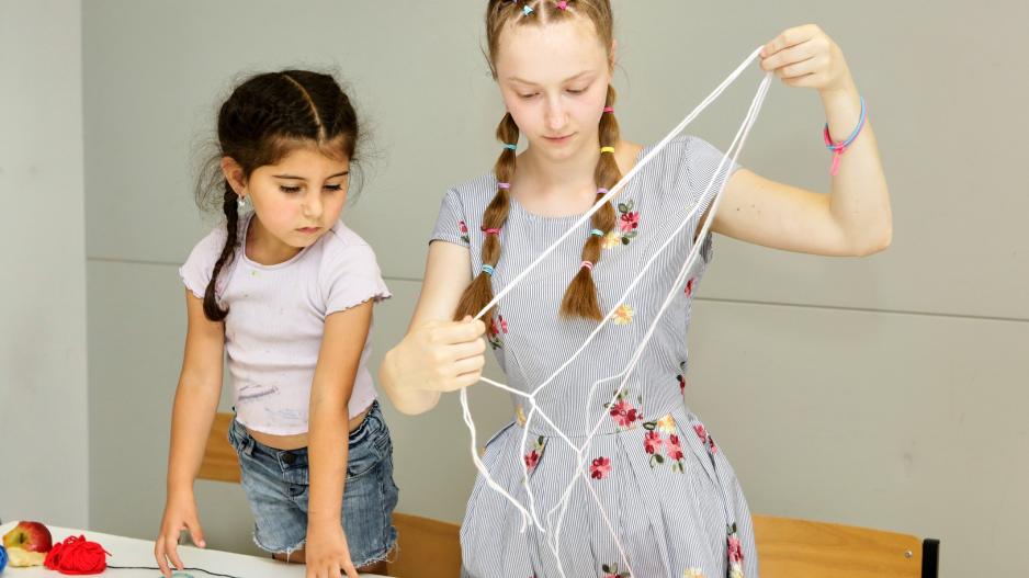 Die 17-jährige Viktoriia knüpft gerne bunte Armbänder und scheint dabei die Welt um sich herum zu vergessen.