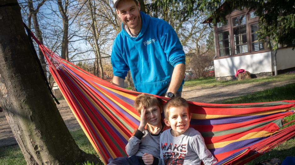 Pädagoge Philipp Schnabel mit Kindern in der Hängematte